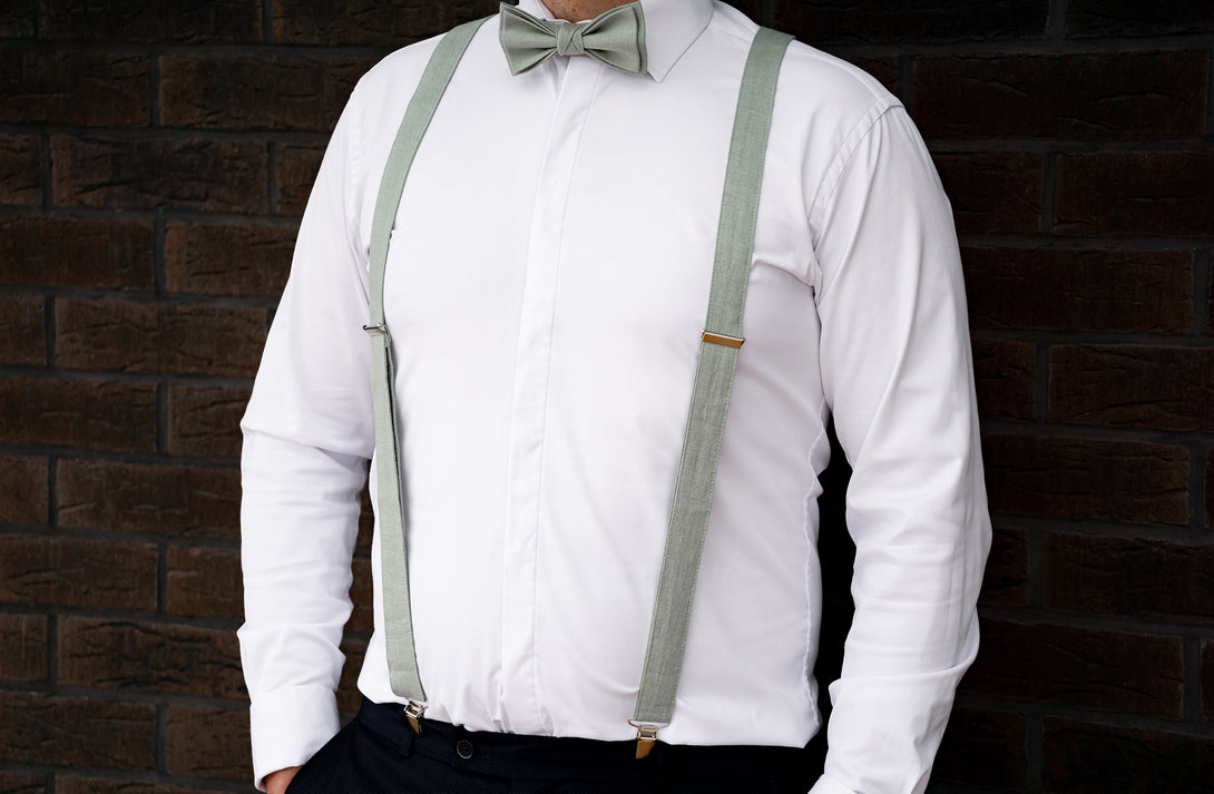 a man wearing a white shirt and green suspenders