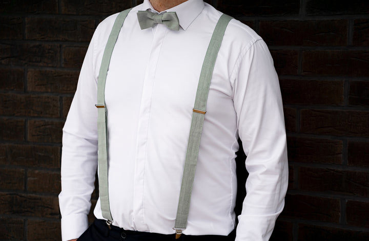 a man wearing a white shirt and green suspenders