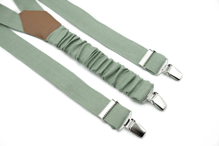 a pair of green suspenders with metal buckles