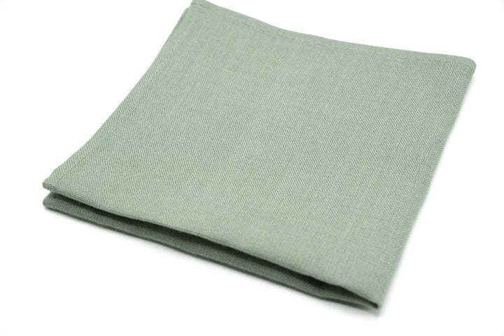 a plain green cloth folded on a white surface