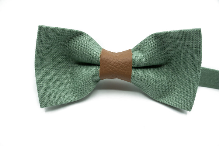 Array of sage green bow ties with central leather straps, showcasing different shades and styles.